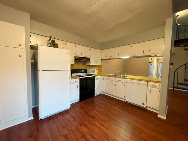a kitchen with a refrigerator and a stove top oven