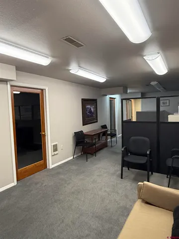 a living room with furniture and a air conditioner vent