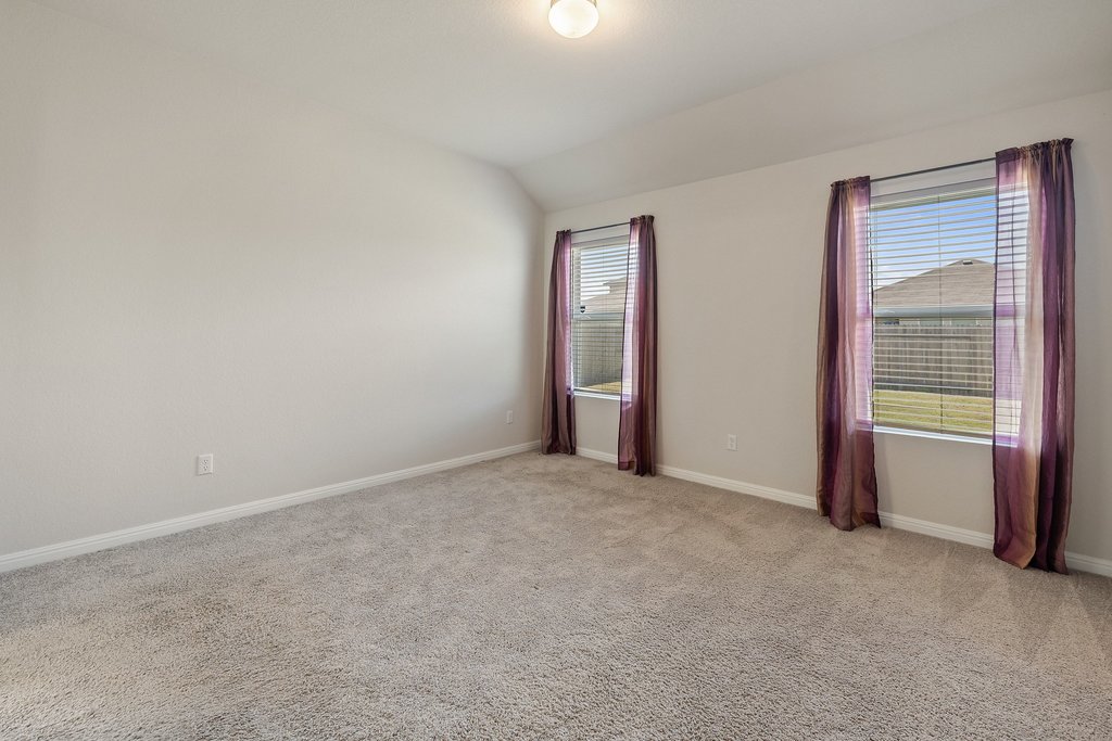 105 Cupa Monti Road Hutto, TX 78634 - Photo 13 of 28 Primary Bedroom with light colored carpet and lofted ceiling