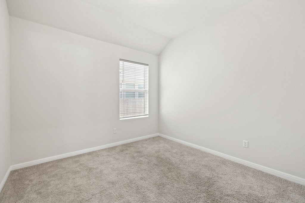 105 Cupa Monti Road Hutto, TX 78634 - Photo 20 of 28 Carpeted empty room with vaulted ceiling and baseboards