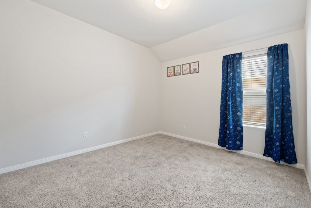 105 Cupa Monti Road Hutto, TX 78634 - Photo 21 of 28 Spare room featuring light carpet and vaulted ceiling