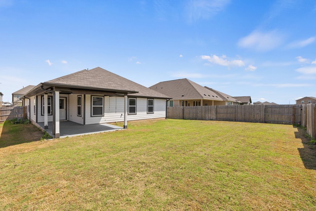 105 Cupa Monti Road Hutto, TX 78634 - Photo 25 of 28 Rear view of house with a fenced backyard, a patio area, and a shingled roof