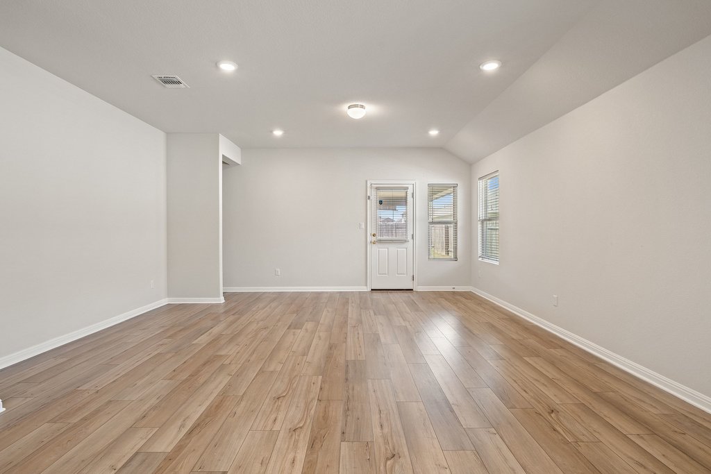 105 Cupa Monti Road Hutto, TX 78634 - Photo 9 of 28 Unfurnished room featuring vaulted ceiling, recessed lighting, and light wood-type flooring