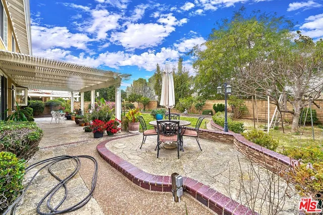 a view of a patio with couches table and chairs and potted plants