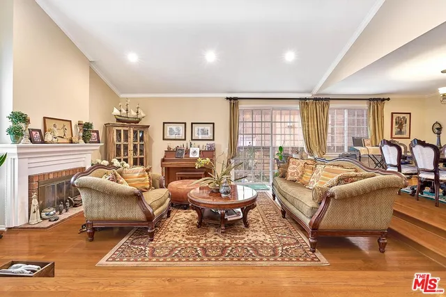 a living room with fireplace furniture and a large window