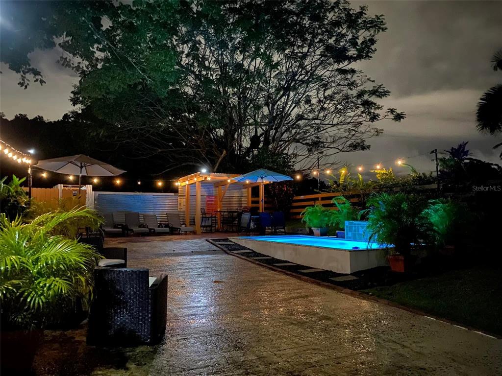 a view of a swimming pool with an outdoor seating and a potted plant