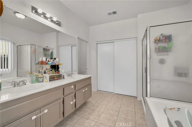 a bathroom with a double vanity sink mirror and shower
