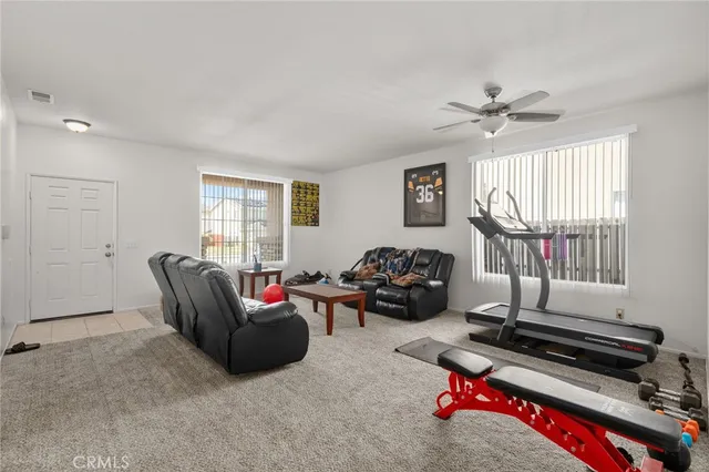 a living room with furniture a window and a flat screen tv