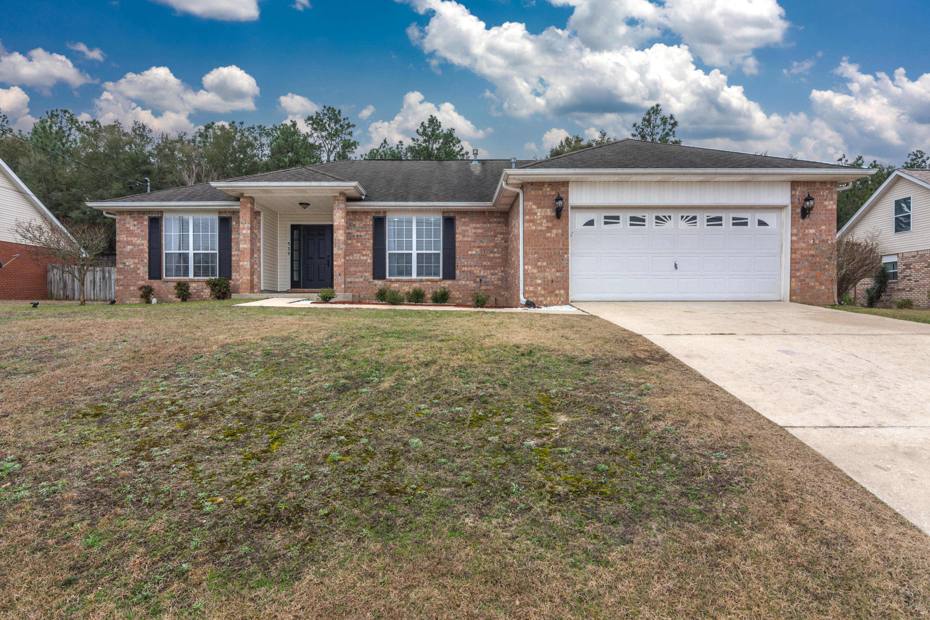 a front view of a house with a yard and a garage