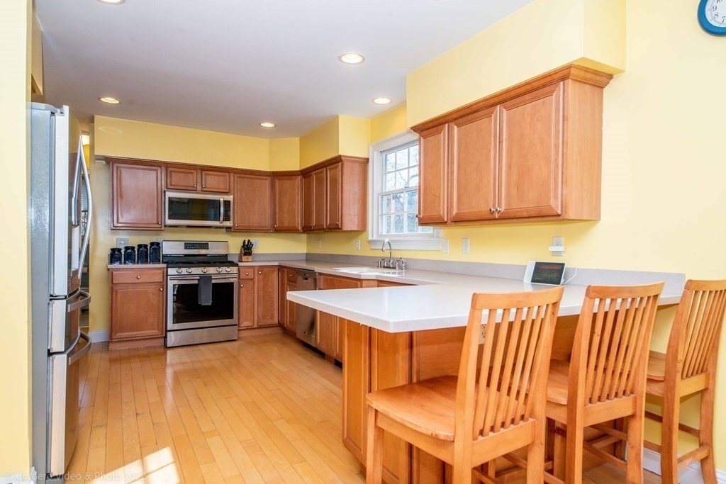 989 Walnut Plain Road Rochester, MA 02770 - Photo 13 of 41 a kitchen with stainless steel appliances granite countertop a stove top oven a sink and a refrigerator