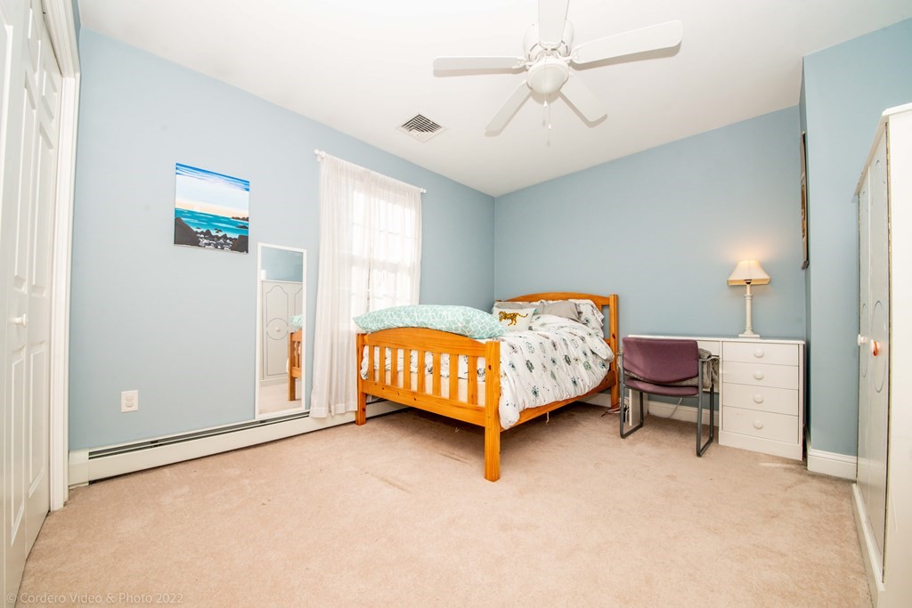 989 Walnut Plain Road Rochester, MA 02770 - Photo 32 of 41 a bedroom with a bed and a chandelier