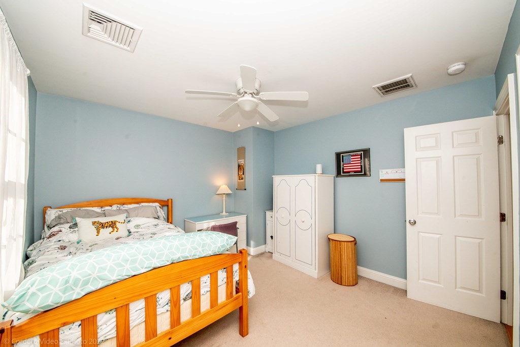 989 Walnut Plain Road Rochester, MA 02770 - Photo 33 of 41 a bedroom with a bed and a chandelier