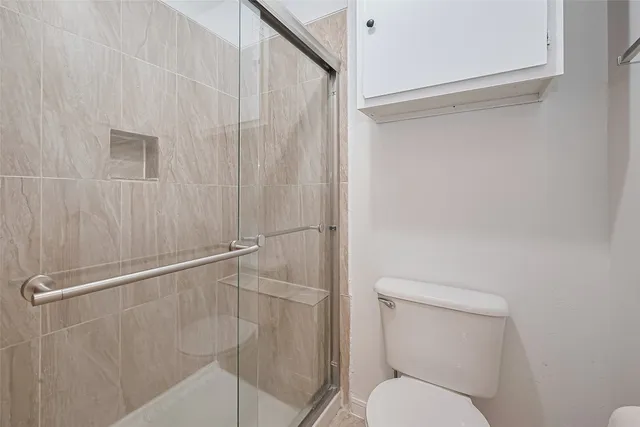 a bathroom with a toilet and a shower