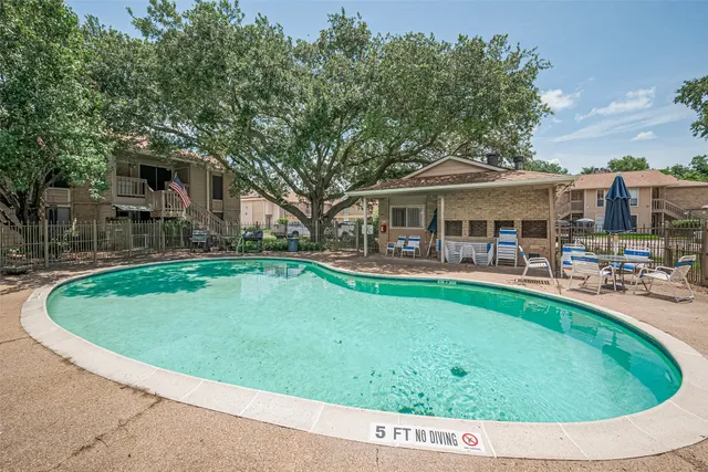 a view of a house with a swimming pool and sitting area