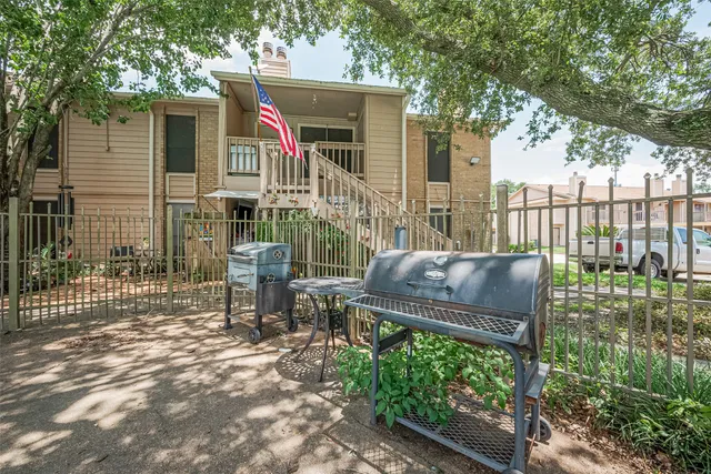 a view of a chair and table in backyard of the house