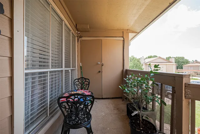 a balcony with a potted plant and outdoor seating