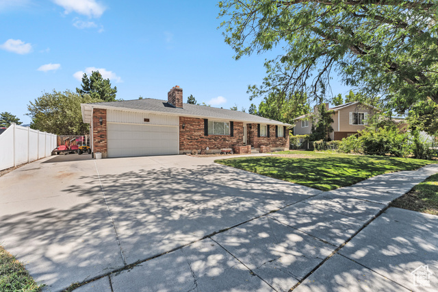 8843 Capernaum Road West Jordan, UT 84088 - Photo 2 of 31 View of front of property with brick siding, driveway, a garage, and a chimney