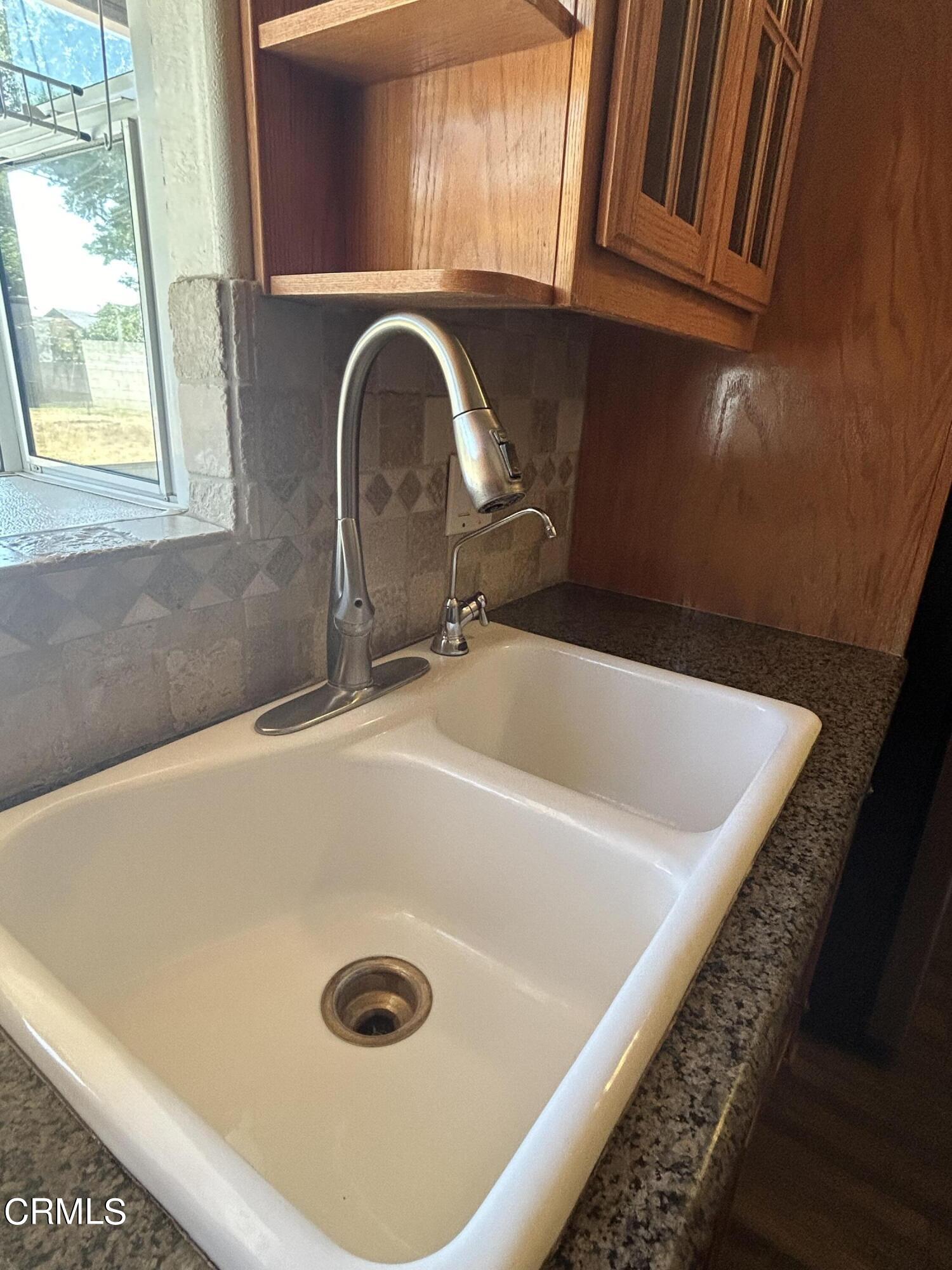 323 Sycamore Street Santa Paula, CA 93060 - Photo 8 of 20 a close view of a sink a faucet and a hard wood floor