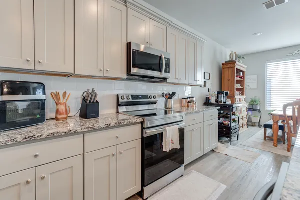 a kitchen with stainless steel appliances granite countertop a sink a stove and cabinets