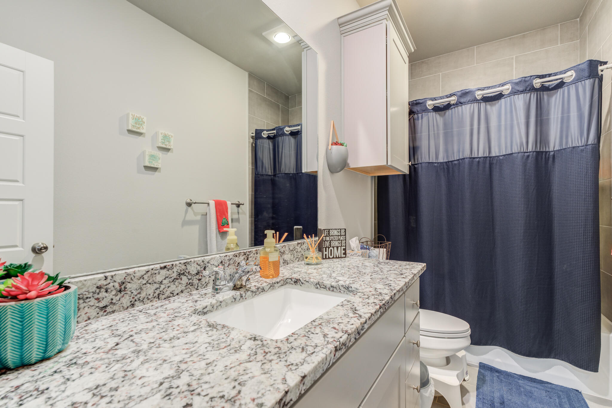 5802 Winfield Avenue Lubbock, TX 79407 - Photo 19 of 36 a bathroom with a granite countertop sink and a mirror
