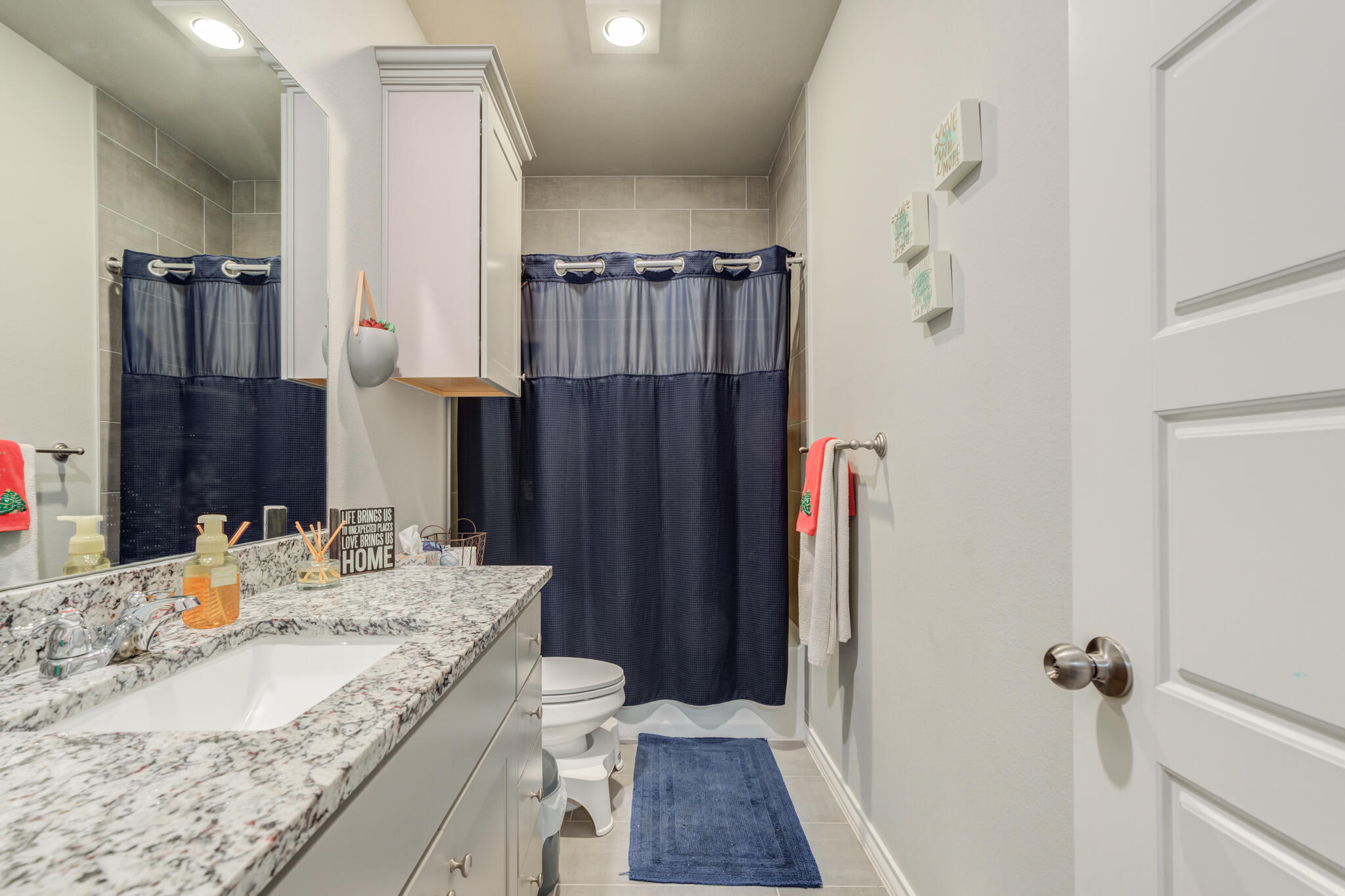 5802 Winfield Avenue Lubbock, TX 79407 - Photo 20 of 36 a bathroom with a granite countertop sink a toilet and shower