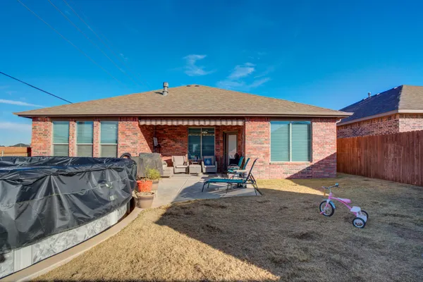 a view of a house with backyard and sitting area