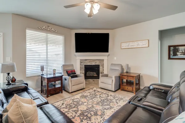 a living room with furniture a flat screen tv and a fireplace