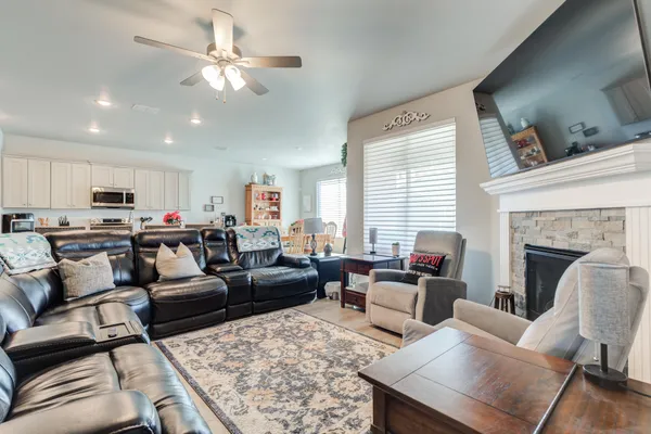 a living room with furniture kitchen view and a fireplace
