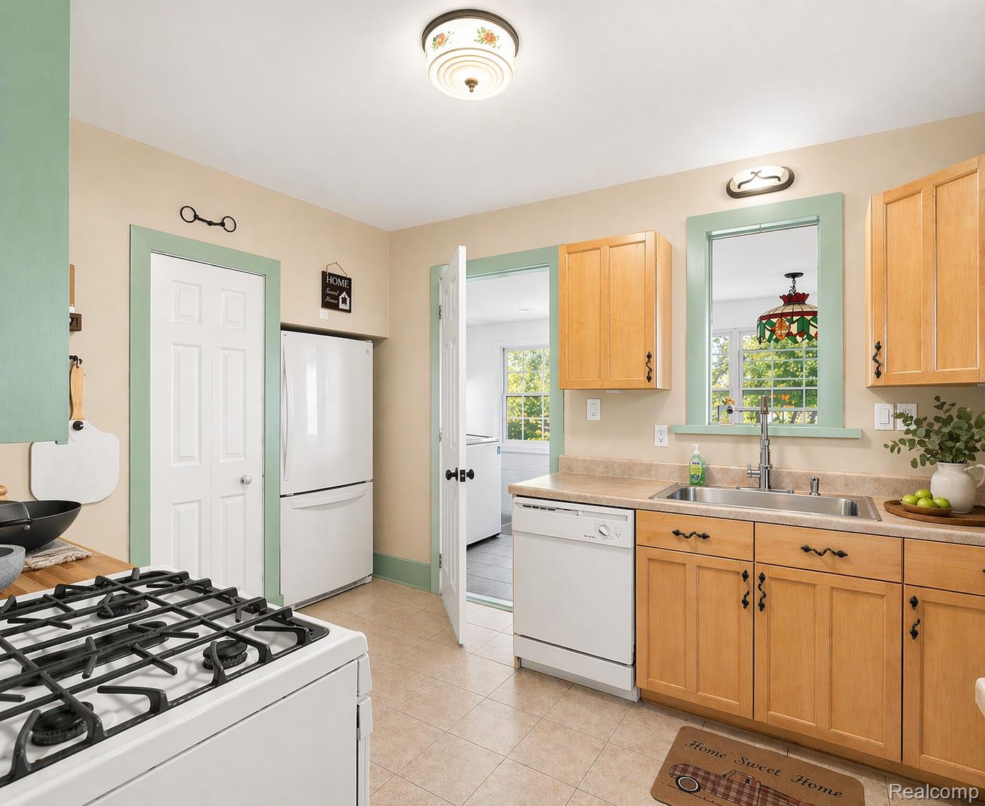 5815 Chicago Road Warren, MI 48092 - Photo 38 of 47 Kitchen with white appliances, light wood finish cabinetry, light countertops, and light tile patterned floors