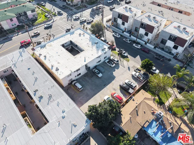 an aerial view of a city with lots of residential buildings and mountain view in back