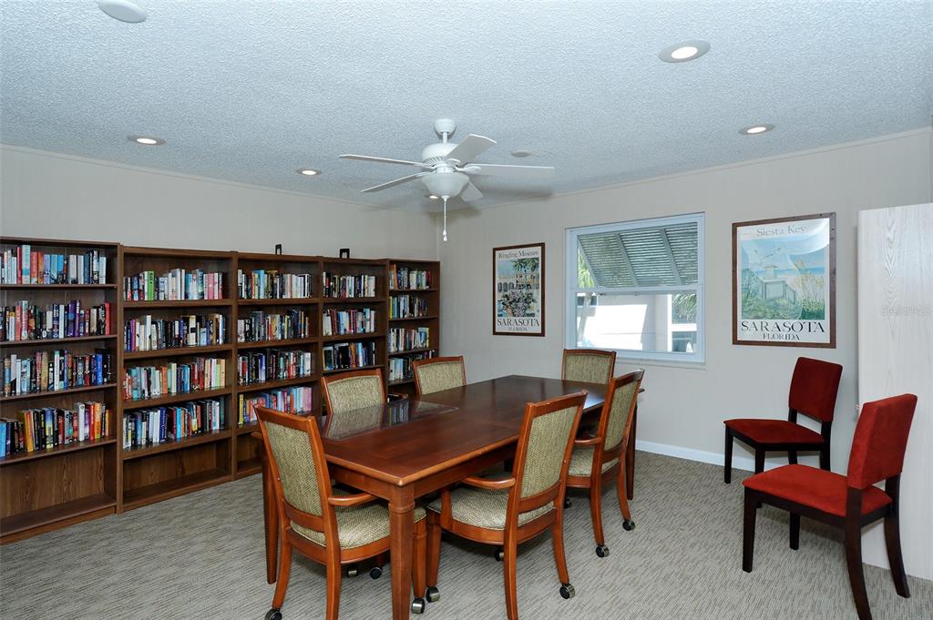 5641 Midnight Pass Road, Unit 904 Sarasota, FL 34242 - Photo 16 of 24 a view of a dining room with furniture and a bookshelf