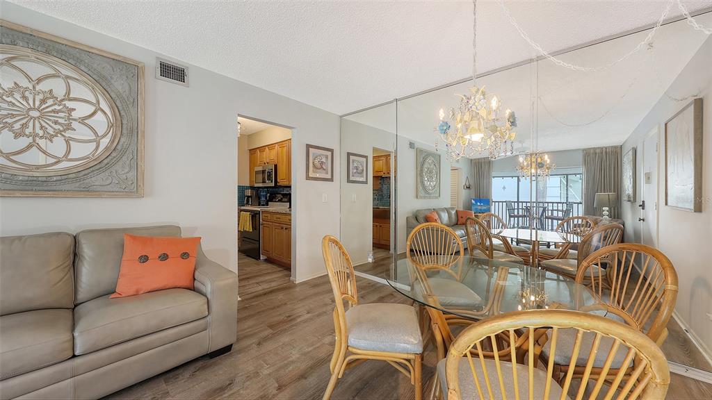 5641 Midnight Pass Road, Unit 904 Sarasota, FL 34242 - Photo 3 of 24 a living room with furniture a chandelier and kitchen view