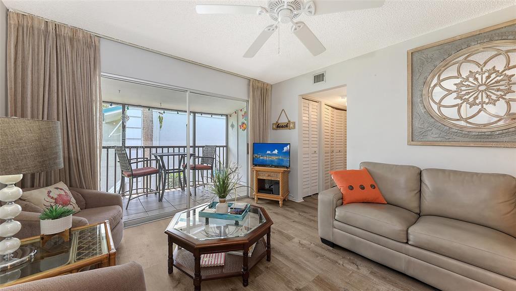 5641 Midnight Pass Road, Unit 904 Sarasota, FL 34242 - Photo 6 of 24 a living room with furniture and a wooden floor