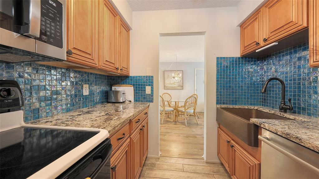 5641 Midnight Pass Road, Unit 904 Sarasota, FL 34242 - Photo 10 of 24 a kitchen with stainless steel appliances granite countertop a sink stove and cabinets