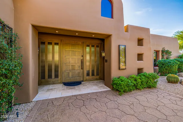 a view of a livingroom with a fireplace a chandelier and front door