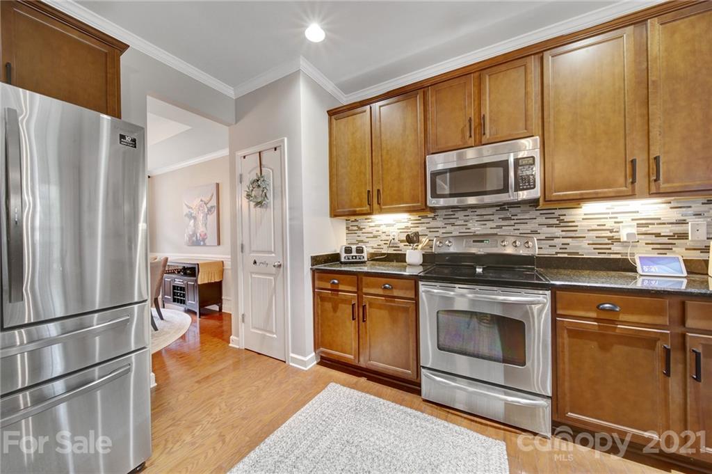 823 Solandra Way Tega Cay, SC 29708 - Photo 13 of 43 a kitchen with granite countertop a refrigerator stove and microwave