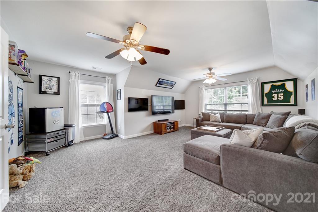 823 Solandra Way Tega Cay, SC 29708 - Photo 25 of 43 a living room with furniture a flat screen tv and a ceiling fan