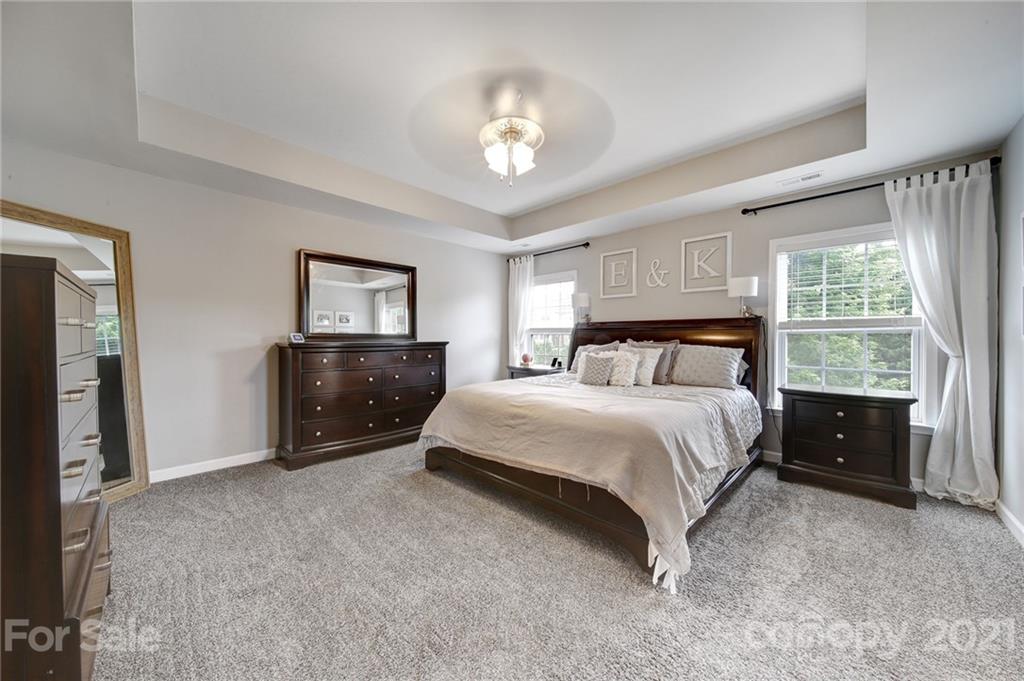 823 Solandra Way Tega Cay, SC 29708 - Photo 29 of 43 a spacious bedroom with a bed and a chandelier