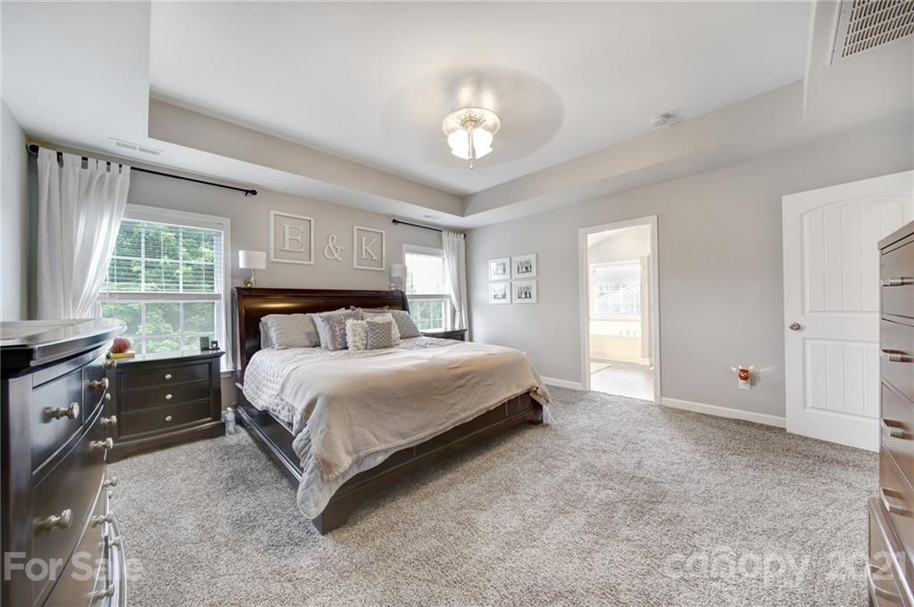 823 Solandra Way Tega Cay, SC 29708 - Photo 30 of 43 a spacious bedroom with a large bed and a chandelier