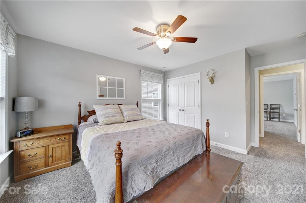 823 Solandra Way Tega Cay, SC 29708 - Photo 37 of 43 a bedroom with a large bed and a chandelier