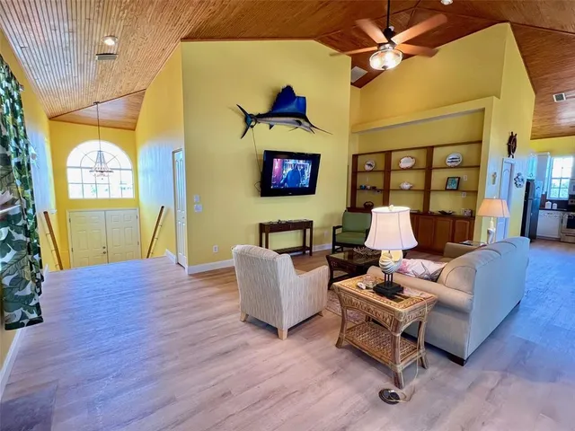 a view of swimming pool with seating space and trees in the background