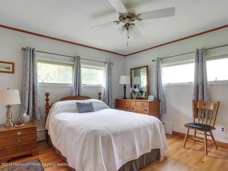 60 Five Points Road Colts Neck, NJ 07722 - Photo 9 of 37 a bedroom with a large bed and a chandelier