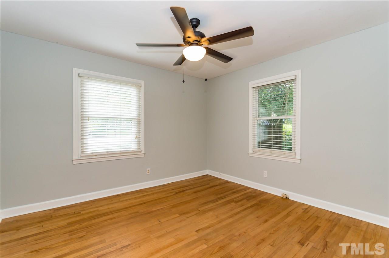 507 Brooks Avenue Raleigh, NC 27607 - Photo 12 of 20 a view of an empty room with wooden floor and a window
