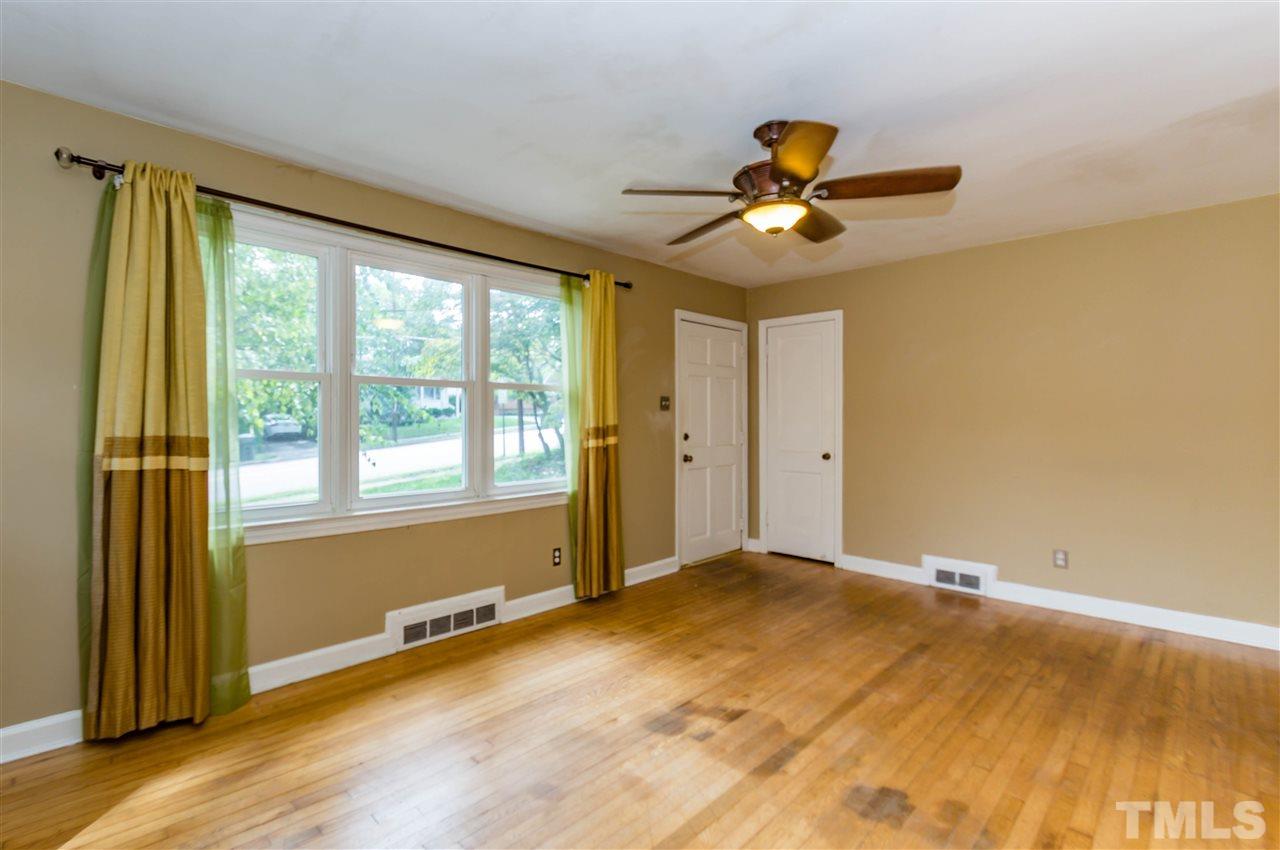 507 Brooks Avenue Raleigh, NC 27607 - Photo 4 of 20 a view of an empty room with wooden floor and a window