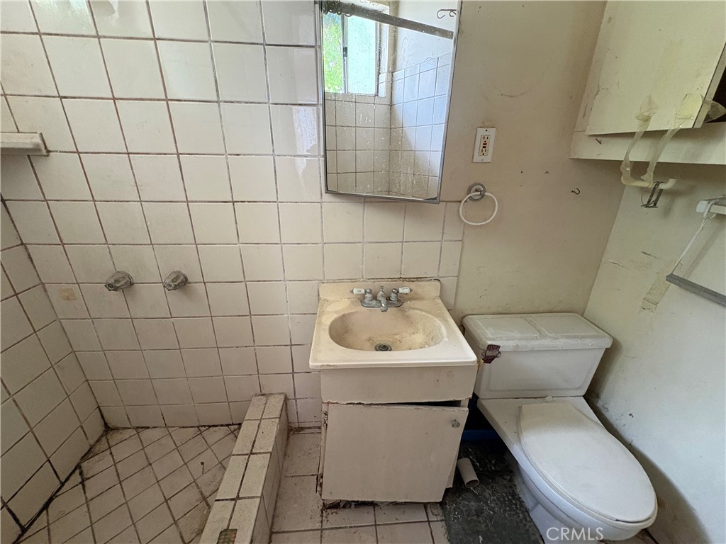 14023 Studebaker Road Norwalk, CA 90650 - Photo 24 of 33 a white toilet sitting next to a white sink and vanity