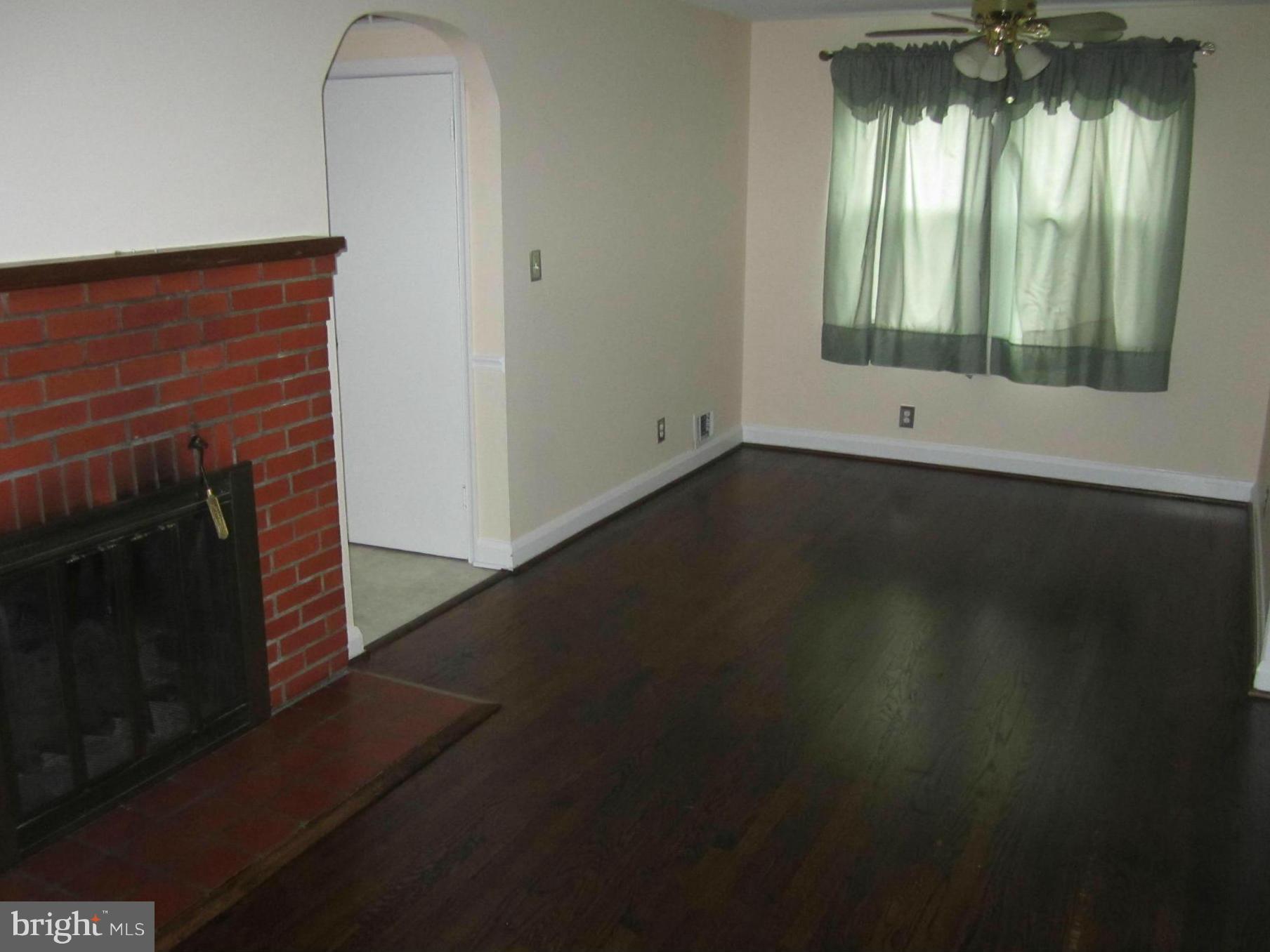 424 West Maple Road Linthicum, MD 21090 - Photo 11 of 24 a view of an empty room with wooden floor and a fireplace