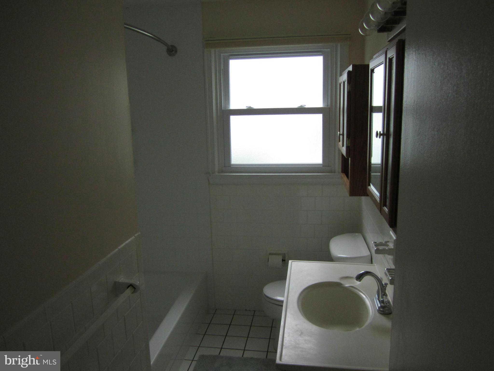 424 West Maple Road Linthicum, MD 21090 - Photo 15 of 24 a bathroom with a toilet a sink and a window