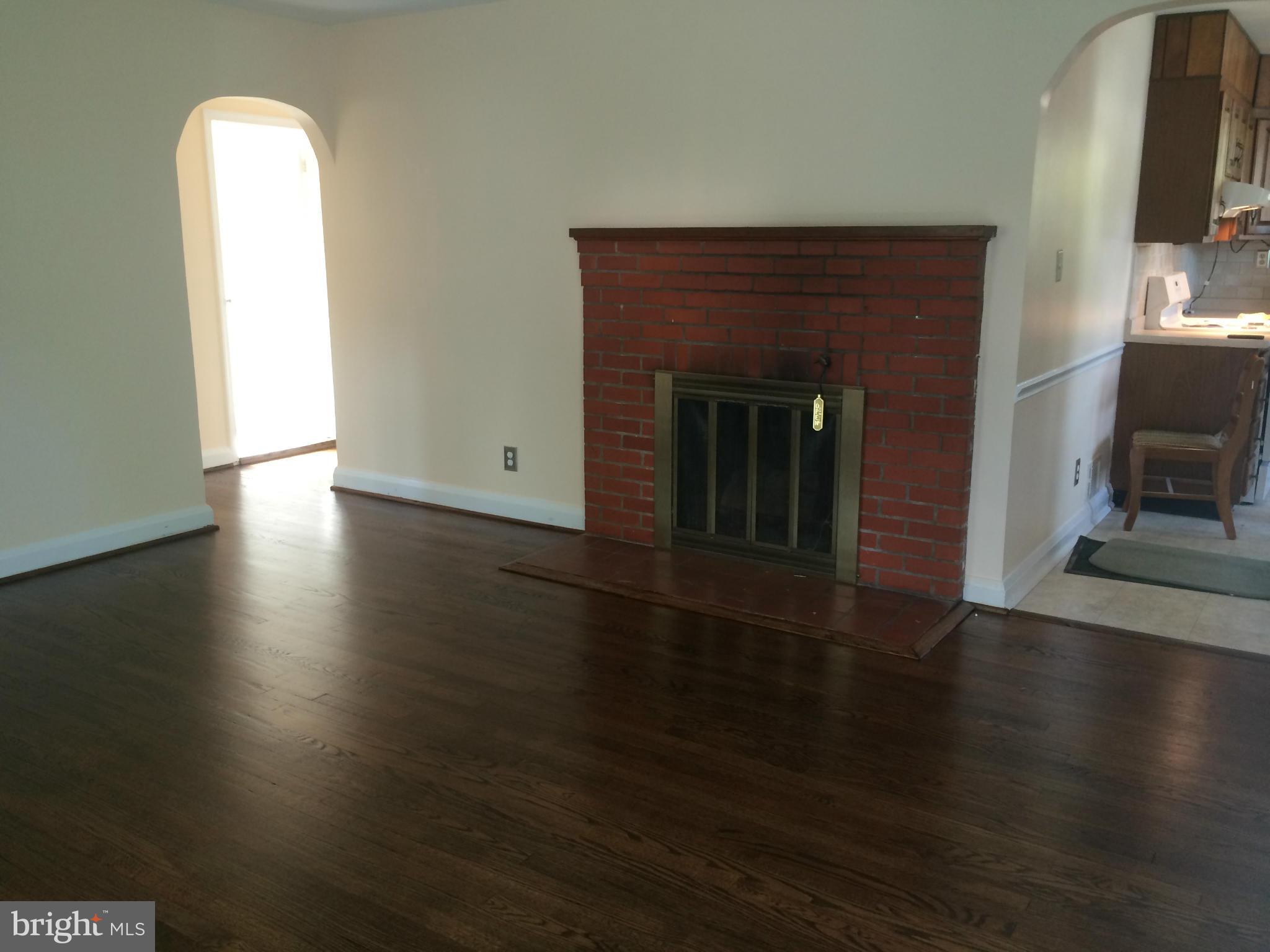 424 West Maple Road Linthicum, MD 21090 - Photo 6 of 24 a view of a livingroom with wooden floor and a fireplace