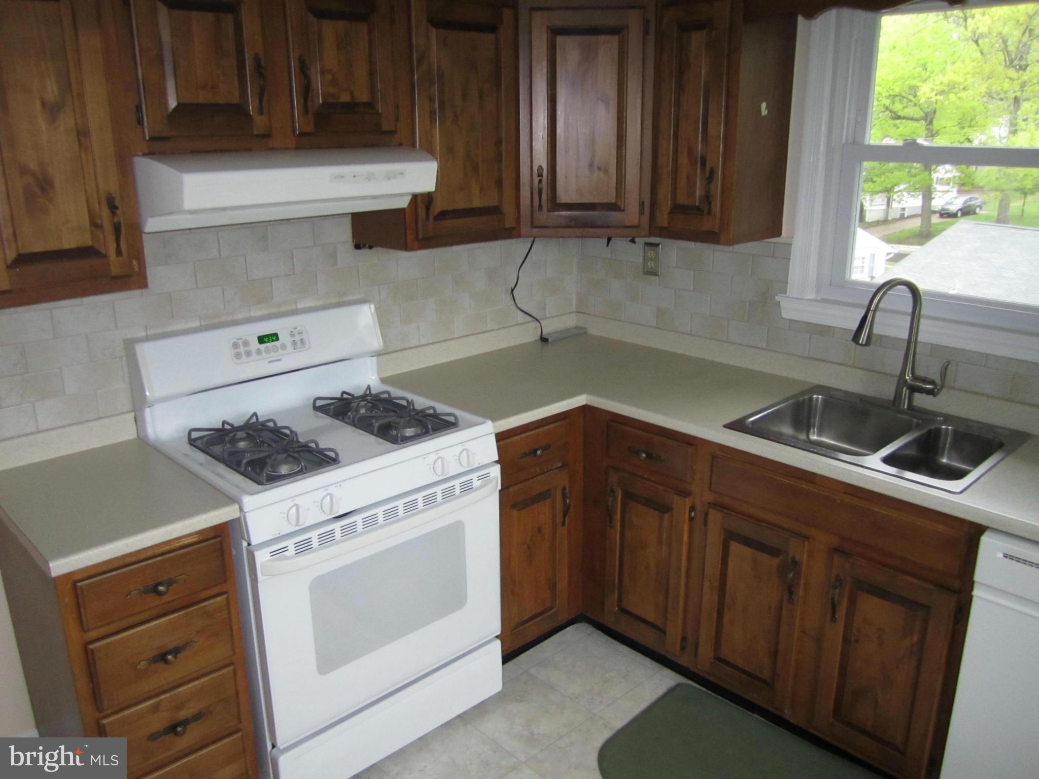424 West Maple Road Linthicum, MD 21090 - Photo 8 of 24 a kitchen with granite countertop a sink stove and cabinets