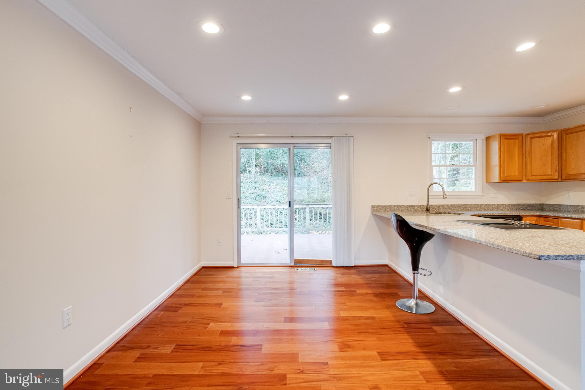 795 Windgate Drive Annapolis, MD 21409 - Photo 11 of 61 a view of a kitchen with kitchen island a sink wooden floor and a large window